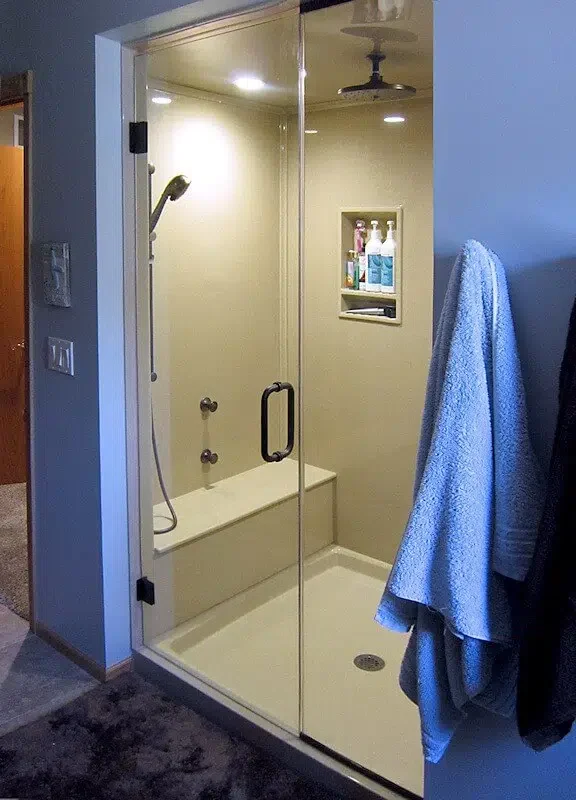 Walk-in shower with built-in bench completed by Excellence in Baths